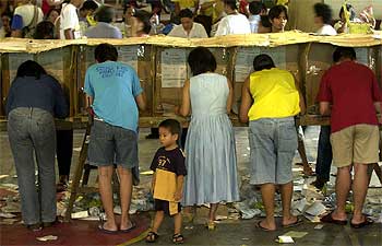 Un niño espera a que su madre termine de votar en un colegio de Manila.