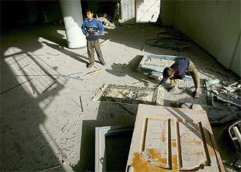 Un niño recoge lo poco que queda de su casa en Gaza.