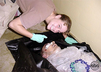 La soldado Sabrina Harman sonríe junto al cadáver de un iraquí.