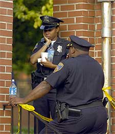 Dos agentes de Baltimore se lamentan en la puerta del complejo de apartamentos donde se cometió el infanticidio.