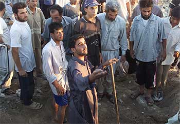 Un grupo de habitantes de Faluya, durante las labores de rescate en el cráter dejado por el ataque aéreo.
