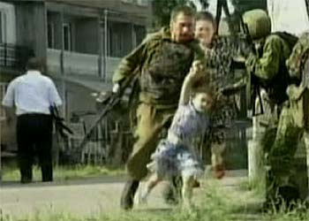 Soldados rusos rescatan a una alumna de esta escuela de Beslán, ciudad de esta pequeña república que limita con Chechenia.