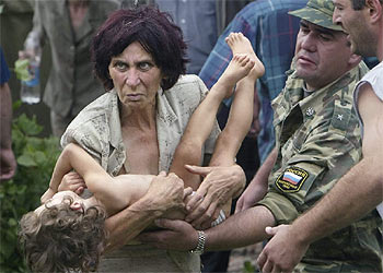 Una mujer carga en brazos a un niño pequeño tras escapar del  secuestro en la escuela.