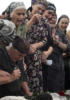 Los familiares de uno de los niños muertos en el asalto al colegio de Beslán lloran junto al féretro con sus restos.