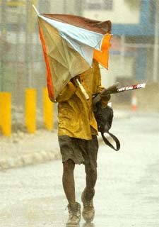 Un jamaicano lucha contra la fuerza de los vientos que levanta  Iván .