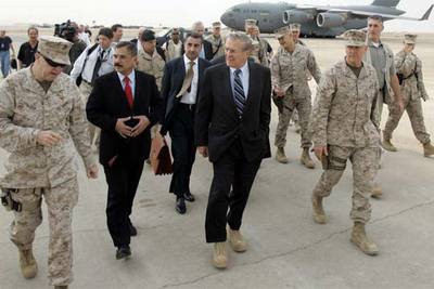 Donald Rumsfeld junto al Ministro de Defensa iraquí, Hazim al Sha'laan, en el campo militar Assad de Irak.