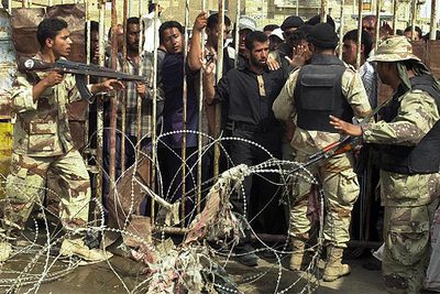 Decenas de iraquíes hacen cola para entregar sus armas en el estadio Al Sinaa de Sadr City.