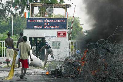 En la imagen, grupos de rebeldes atacan con piedras la base francesa en Abidjan.