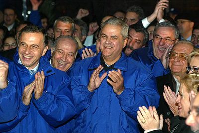 El primer ministro rumano y candidato a la Presidencia, Adrian Nastase, en el centro, aplaude tras conocer los primeros resultados.