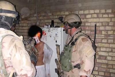 Dos presuntos  marines  custodian a un hombre con una herida en la cabeza.