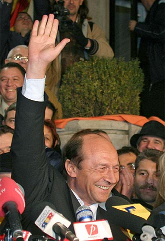 El candidato de la oposición liberal-demócrata, Traian Basescu, saluda a sus seguidores tras conocer los sondeos.