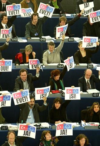 Varios eurodiputados muestras pancartas con la palabra 