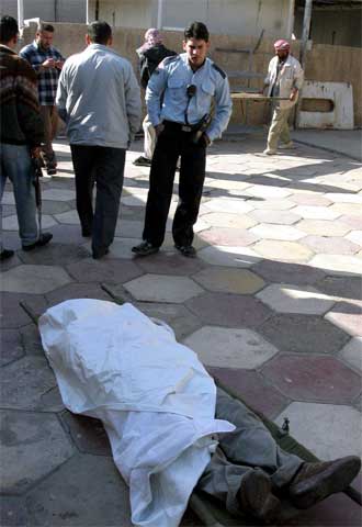 El cadáver de un hombre yace en las cercanías del lugar donde una bomba ha estallado al paso de un microbús en Yusifiya.