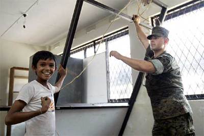 Un niño esboza una sonrisa mientras ayuda a un soldado de EE UU en las labores de reconstrucción en Sri Lanka.