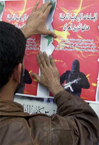 Un hombre pega en una pared de Bagdad un póster que reza: 