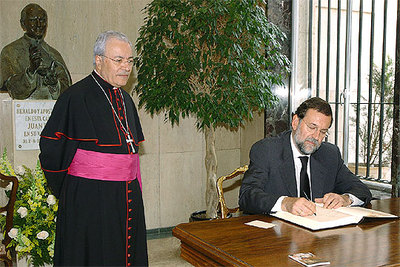 Rajoy firma en el libro de condolencias de la Nunciatura, ante el nuncio en España, Manuel Monteiro de Castro.