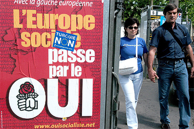 Una pareja pasa junto a los carteles electorales en una calle de París vísperas de la votación.