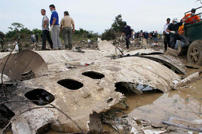 Los equipos de rescate observan los restos del avión que ayer se estrelló en el norte de Venezuela.