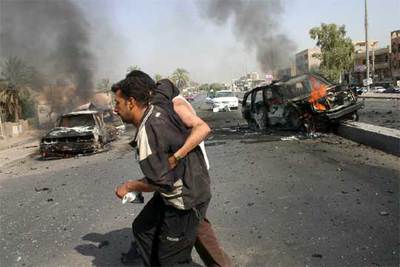 Dos civiles iraquíes escapan de los enfrentamientos entre policías e insurgentes en Bagdad.