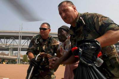 Dos 'marines' conducen a una evacuada hacia un helicóptero en Nueva Orleans.