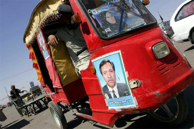 Un afgano exhibe su 'auto-rickshaw' con carteles de candidatos parlamentarios en Herat.