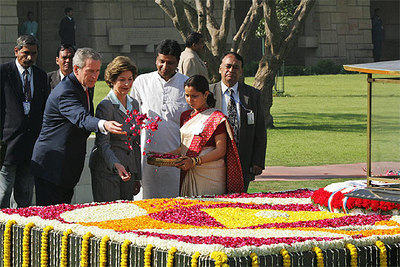 El presidente de EE UU y su esposa, Laura, esparcen pétalos de rosa sobre el memorial de Gandhi en Nueva Delhi.