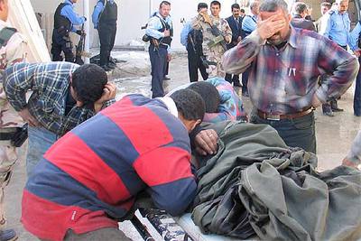 Varios hombres lloran ante el cadáver de uno de los civiles muertos en la localidad de Tikrit.