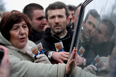 Ciudadanos de Belgrado se agolpan junto al coche fúnebre que traslada los restos mortales de Milosevic.