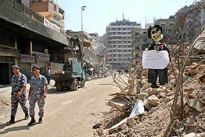 Dos policías libaneses caminan junto a una figura que representa al Primer ministro israelí, Ehud Olmert, en Beirut.