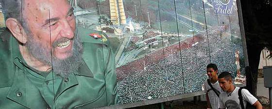 Dos jóvenes pasan frente a una valla con la imagen del líder cubano Fidel Castro en La Habana.