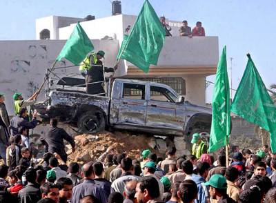 Un grupo de palestinos junto a un camión de Hamas asaltado en Gaza