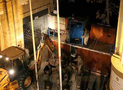 Los grecochipriotas comienzan a derribar la 'Línea Verde' que divide la ciudad de Nicosia. En la imagen trabajos de derribo del muro.