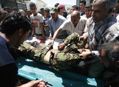 Un miembro de la guardia de Abbas es trasladado en camilla