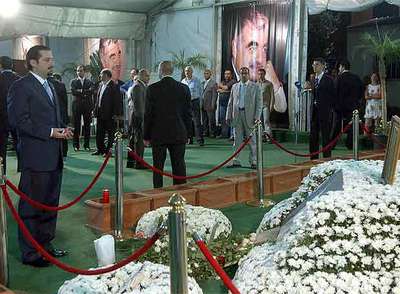 El líder del parlamento Saad Hariri (i) lee el Corán junto a la tumba de su padre, el ex primer ministro Rafik Hariri en Beirut