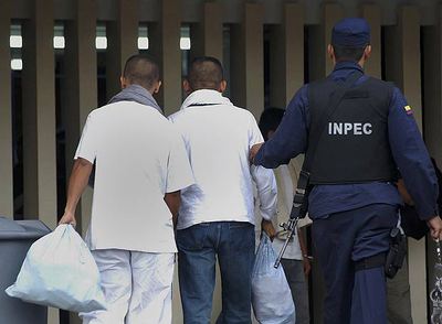 Un policía escolta a dos de los guerrilleros de las FARC trasladados a la prisión de Chiquinquira