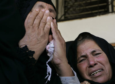Dos mujeres palestinas lloran durante el funeral de Ibrahim Shami, combatiente de los Comités de la Resistencia Popular (CRP)