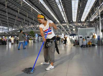 Los manifestantes limpian las instalaciones mientras se preparan para abandonar el principal aeropuerto de Bangkok