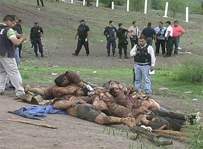 Los agentes de la policía mexicana observan la pila de cadáveres encontrados en Michoacán.