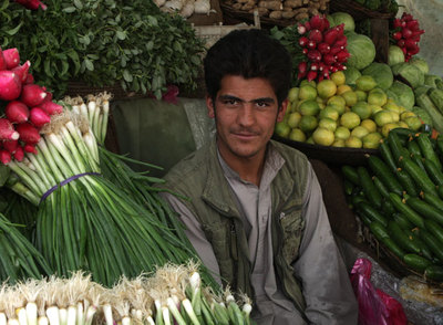 Un comerciante en su puesto en el mercado de las verduras.