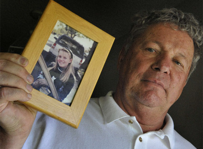 El padrastro de la joven secuestrada sostiene una foto de ella cuando tenía 11 años.