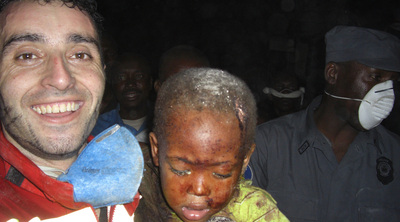 El bombero Óscar Vega abraza al niño al que rescató entre los escombros.