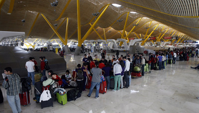 Cientos de pasajeros afectados por las cancelaciones aéreas forman cola frente a los mostradores de Iberia en la terminal 4 del aeropuerto de Barajas.