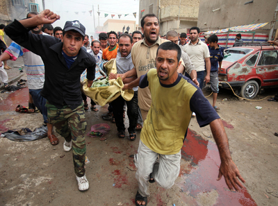 Un grupo de hombres evacua a una de las víctimas heridas en una de la serie de explosiones del bario chií de Ciudad Sadr en Bagdad.