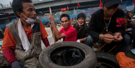 Un grupo de   camisas rojas  descansa tras una barricadas en un campamento levantado en Bangkok.