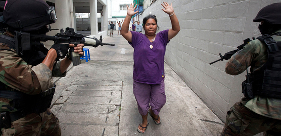 Una  camisa roja  se rinde ante dos soldados tailandeses tras la ofensiva sobre el campamento opositor en Bangkok.
