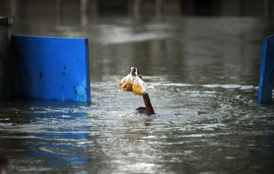 Un niño pakistaní nada sumergido para mantener seca su comida, en el pueblo de Basira, en el Punjab, una de las zonas más afectadas por las inundaciones