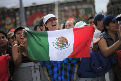 Una mujer ondea una bandera mexicana durante los actos de la plaza del Zócalo.