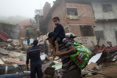 Un hombre y su hijo llevan sus pertenencias tras ser evacuados de una zona con alto riesgo de sufrir un corrimiento de tierra.