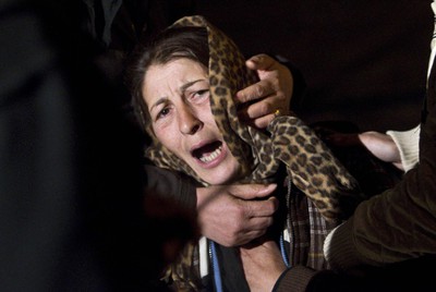 La madre de los cuatro niños fallecidos el domingo en el incendio de un campamento de gitanos en Appia Nuova llora su muerte mientras ve arder la chabola en la que vivían.