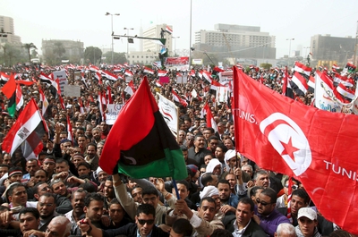 Miles de egipcios se manifiestan en la plaza de la Liberación en El Cairo con banderas tunecinas y libias de la época anterior a Gadafi.